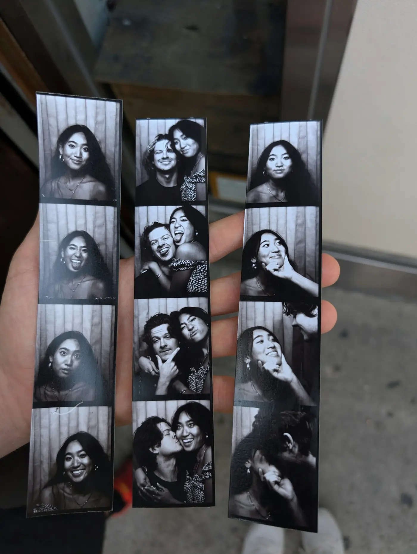 Hand met fotostrookjes uit een photobooth