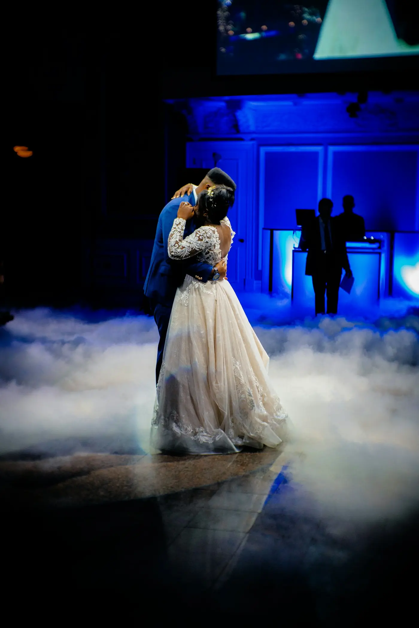Bruidspaar danst de openingsdans op een witte rookdeken